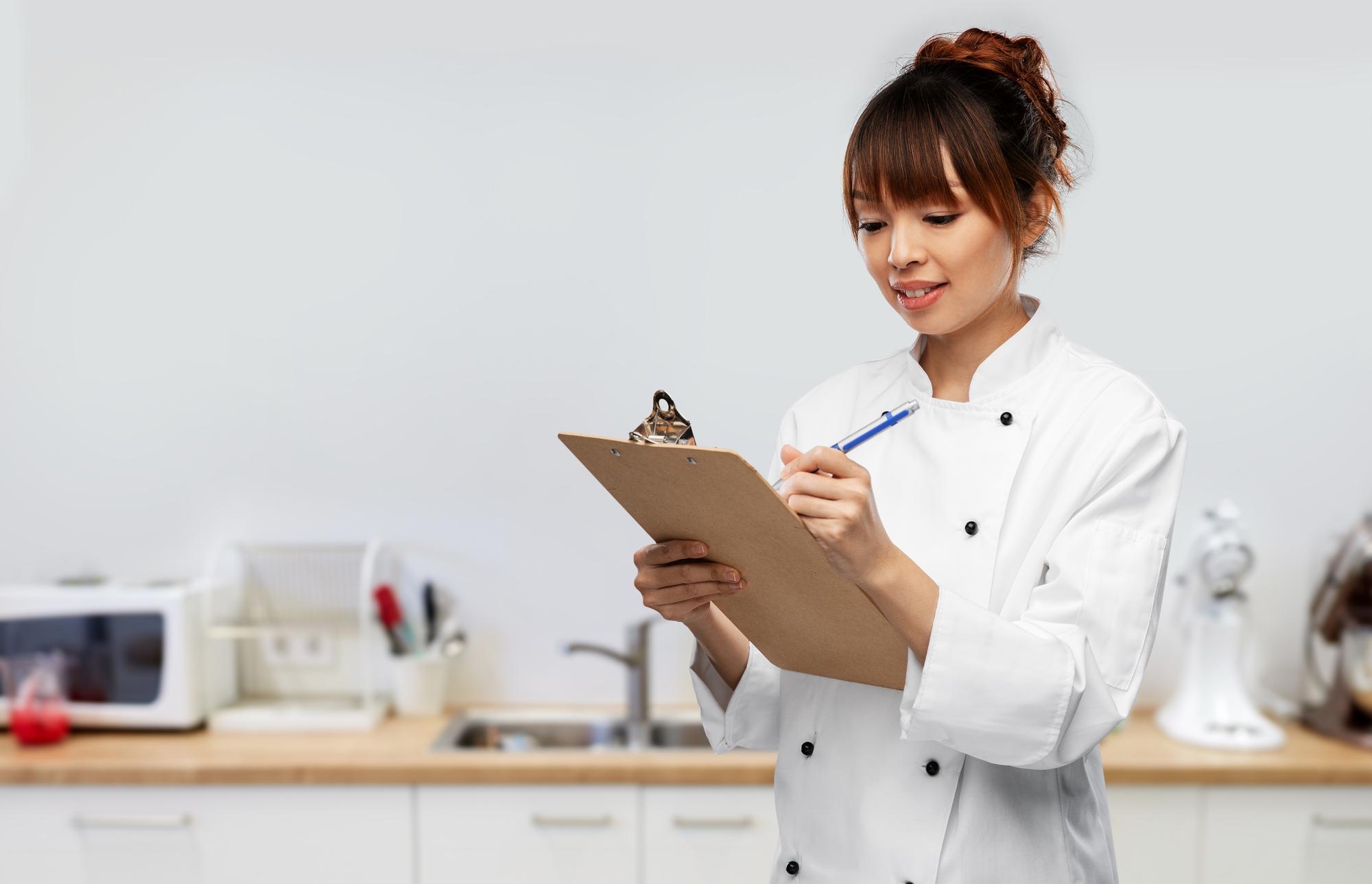Consultant reviewing recipe notes with chef